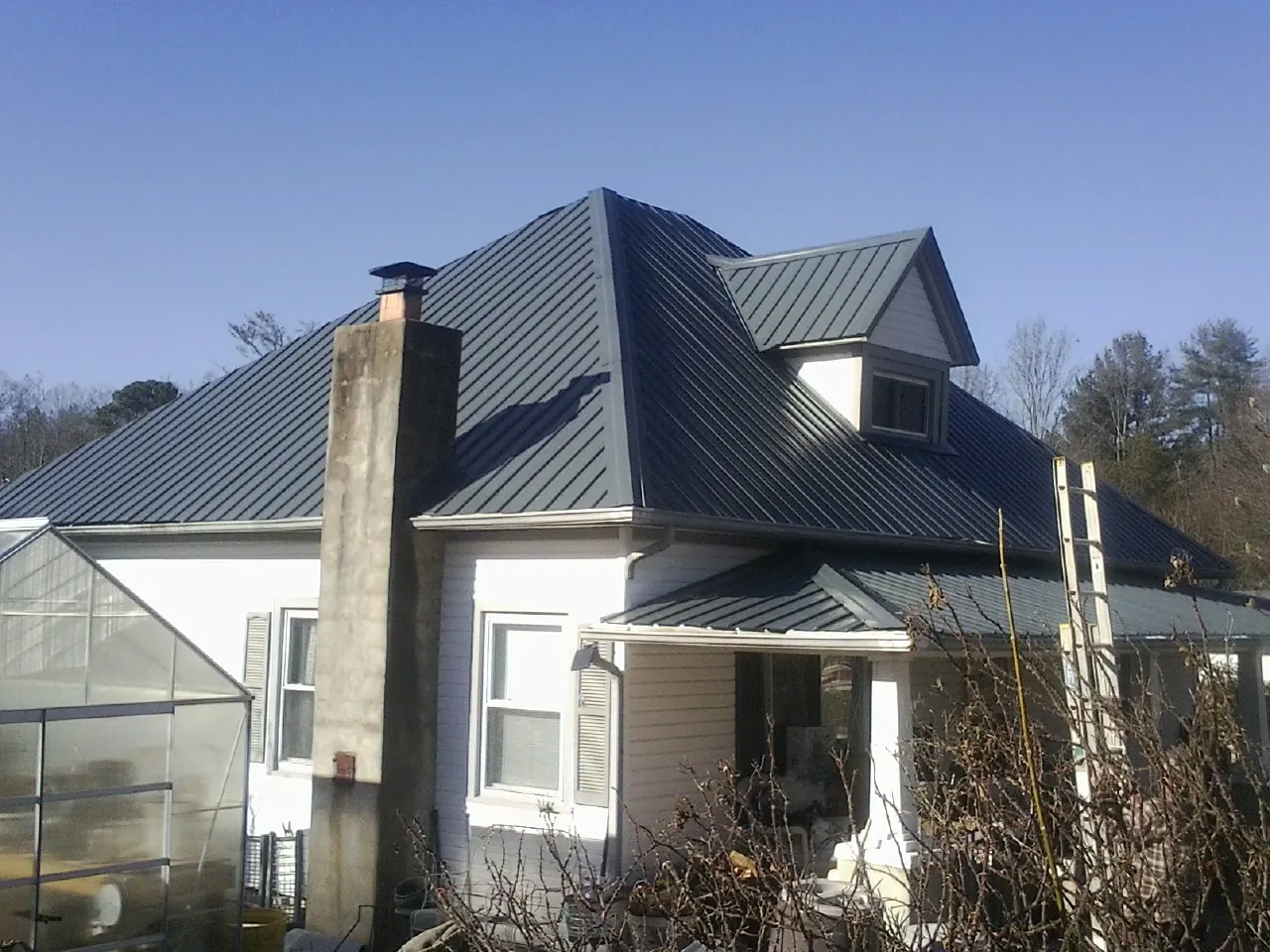Dark blue standing seam metal roof on a white farmhouse with dormer — Slate & Tile Roof Repair by Roofing Brothers in Cornwall On Hudson