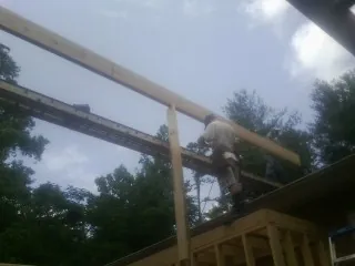 Carpenter setting a ridge beam over a new addition frame — Ice Dam Removal by Roofing Brothers in Cornwall On Hudson