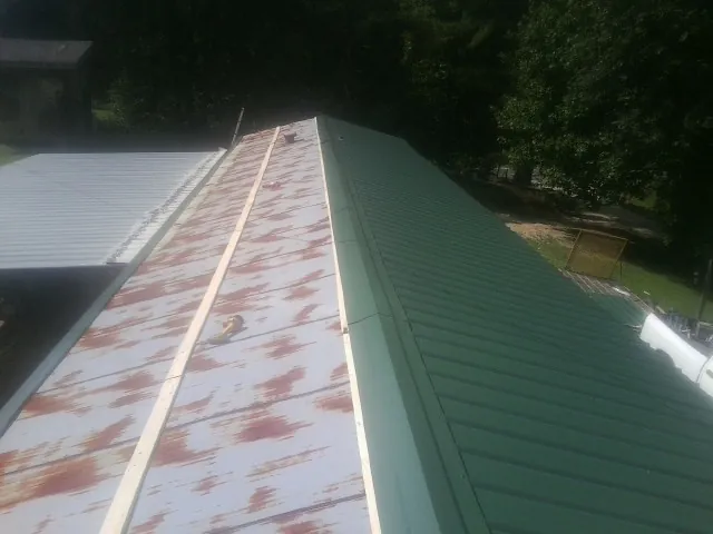 Old rusted panels beside newly installed green metal roofing — Wind Damage Roof Repair by Roofing Brothers in Cornwall On Hudson
