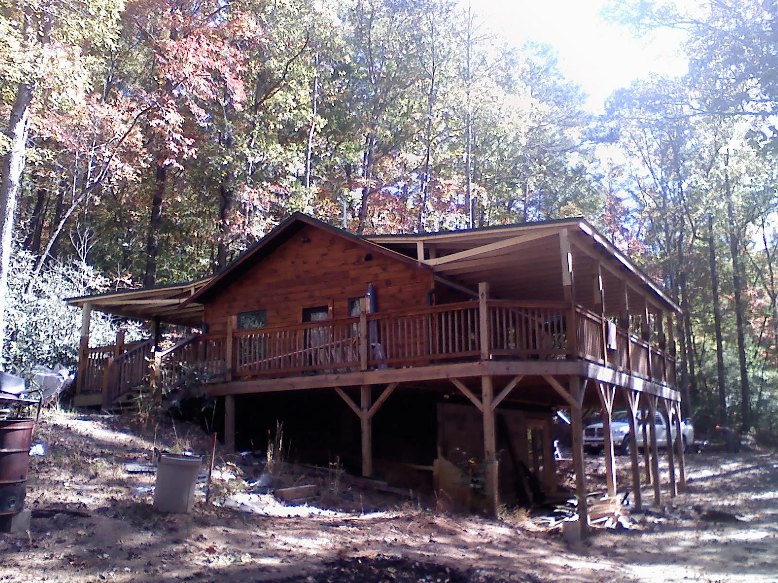 Log cabin with a wraparound porch and metal roof in the fall in Cornwall On Hudson